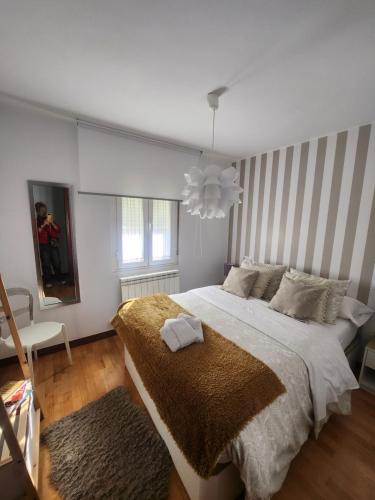 Un dormitorio con una cama grande y una lámpara de araña. en Casa Román centro León Edificio Rehabilitado SIN ASCENSOR, en León