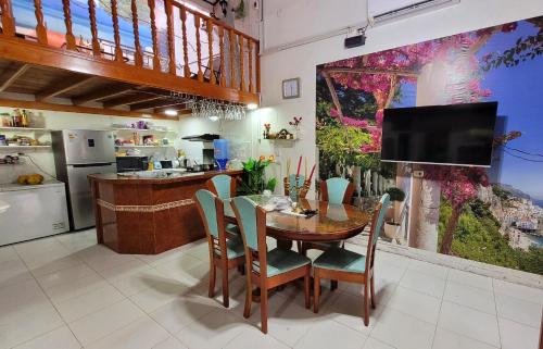 uma cozinha com mesa e cadeiras e uma televisão em Hogar Marujita em Iquitos