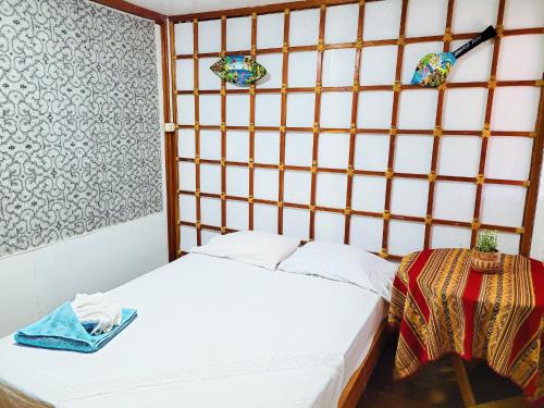 um pequeno quarto com uma cama e uma janela em Hogar Marujita em Iquitos