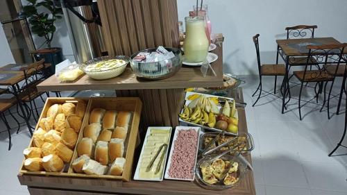 een tafel met verschillende dienbladen van verschillende soorten voedsel bij Let's Go Tour Palace Hotéis in Canaã dos Carajás