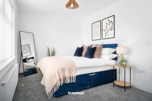 Un dormitorio con una cama azul y blanca con almohadas en NEW Stanley House - Stunning 2 Bedroom House en Etruria