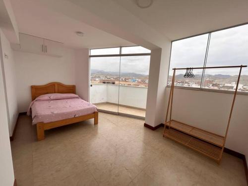 1 dormitorio con 1 cama en una habitación con ventanas en Apartamento familiar de lujo (402), en San Bartolo