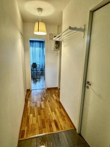 una stanza vuota con un corridoio con una porta e pavimenti in legno di Cozy And Central Apartment a Göteborg