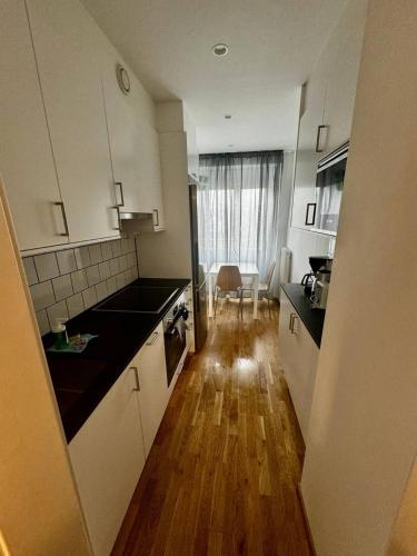 cocina con armarios blancos y suelo de madera en Cozy And Central Apartment en Gotemburgo