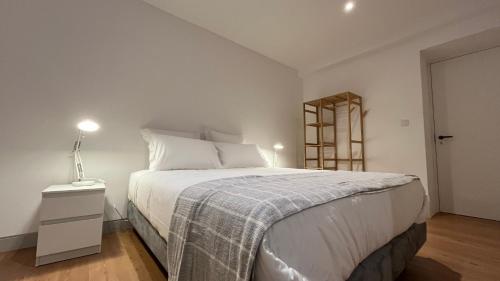 um quarto com uma cama grande e um cobertor em Matriz 55, Hostel & Suites em Ponta Delgada