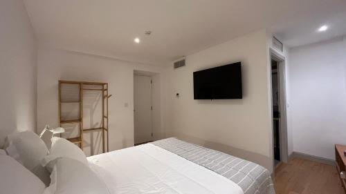 um quarto com uma cama e uma televisão na parede em Matriz 55, Hostel & Suites em Ponta Delgada