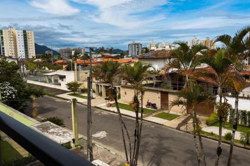 - une vue sur une rue bordée de palmiers et de bâtiments dans l'établissement Pousada Caraguatatuba Praia Indaia Quarto 02, à Caraguatatuba