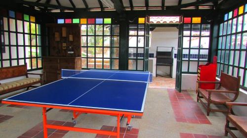 a blue ping pong table in a room with windows at Casa La Carolina in Villa de Leyva