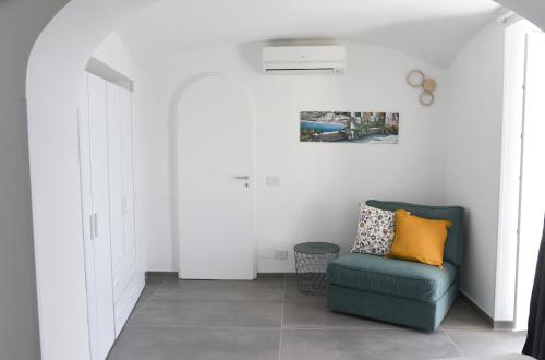a living room with a blue chair and a wall at Amalfi Saracena House in Amalfi