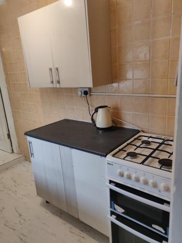 uma cozinha com um fogão e um armário branco em AR Homes em Middlesbrough