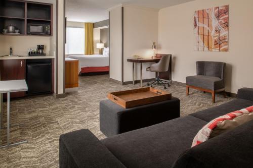 Habitación de hotel con sofá y dormitorio en SpringHill Suites Portland Airport en Portland