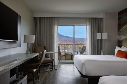 a hotel room with a bed and a balcony at MeadowView Marriott Conference Resort and Convention Center in Kingsport