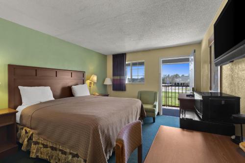 a hotel room with a bed and a balcony at Americas Best Value Inn Edenton in Edenton
