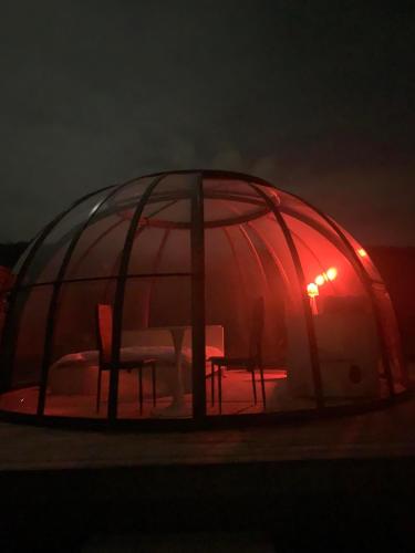 a glass igloo with two chairs and a table in it at La bulle de Mont in Yvoir