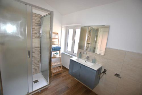 a bathroom with a sink and a glass shower at A Supressa du Capua in Sestri Levante