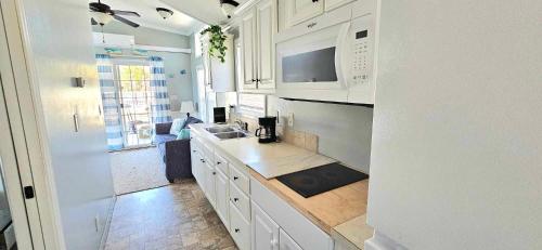 a white kitchen with a sink and a microwave at Down the Shore Campground in Ocean View