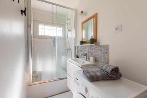 une salle de bain blanche avec un lavabo et une douche dans l'établissement Studio Clémentine Montpellier, à Montpellier