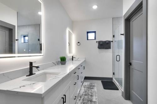 a white bathroom with two sinks and a mirror at Vizcaya #6 - Moab's Newest Luxury Rental in Moab