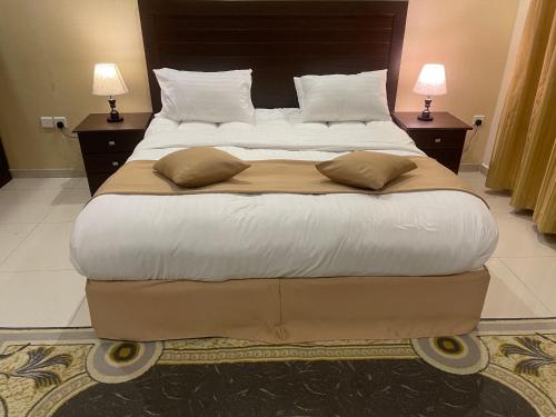 راما للاجنحة الفندقية في جدة: سرير كبير في غرفة الفندق مع مصباحين