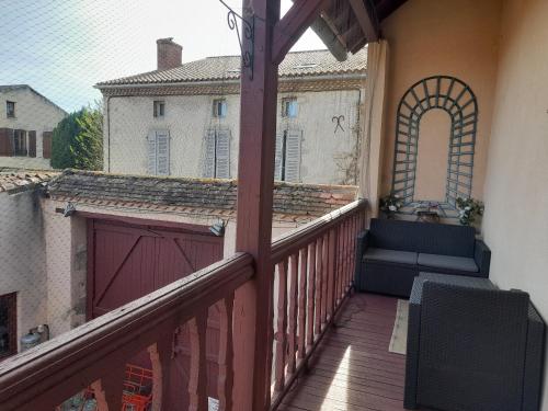 a balcony with a bench and a building at La Maison du Prince de Condé in Charroux-dʼAllier