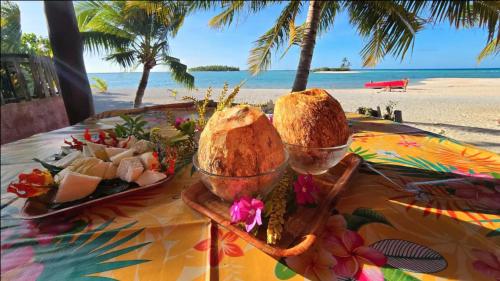 ein Tisch mit Brot und ein Teller Essen am Strand in der Unterkunft Tikehau HereArii Airbnb in Tikehau