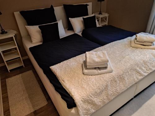 a large bed with black and white sheets and pillows at Das Bergherz Ruhe + Natur pur in Reken