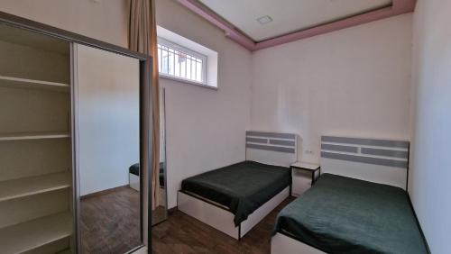 1 dormitorio con 2 camas y espejo en Puzzle Space, en Ereván