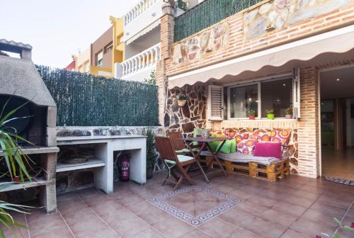 a patio with a fireplace and a table and chairs at Villa del Mar in Puebla de Farnals