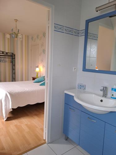 y baño con cama, lavabo y espejo. en B&B La Rive - Le Mont Saint Michel en Ardevon