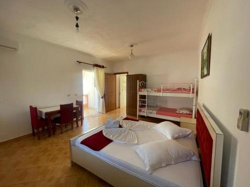 Un dormitorio con una cama y un comedor. en Vila Florand Sela, en Ksamil