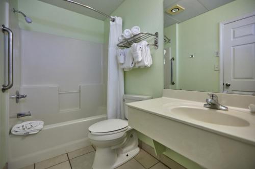 ein Bad mit einem WC, einem Waschbecken und einer Dusche in der Unterkunft Palmetto Beachfront Hotel, a By The Sea Resort in Panama City Beach
