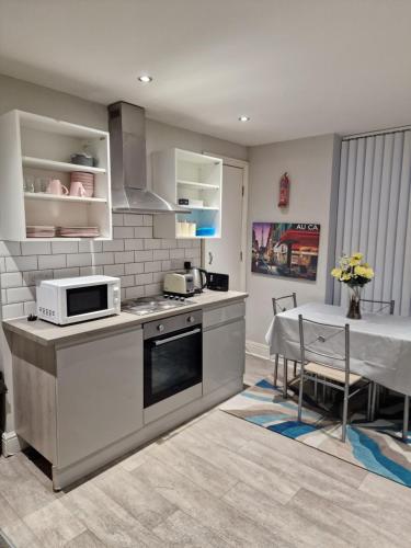 a kitchen with a stove and a table in it at Spacious Double Bedroom in Liverpool