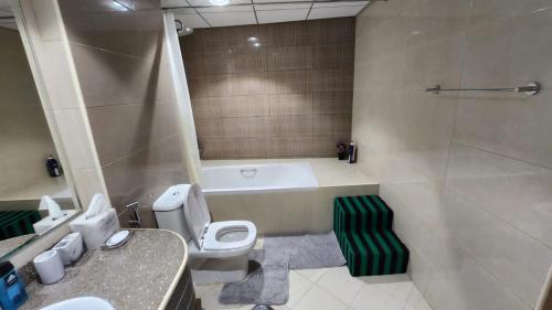 a bathroom with a tub and a toilet and a sink at Ocean View Luxury Suites in Ajman 