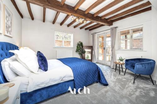 a bedroom with a bed and a blue chair at NEW - Country House, Staffordshire in Abbots Bromley