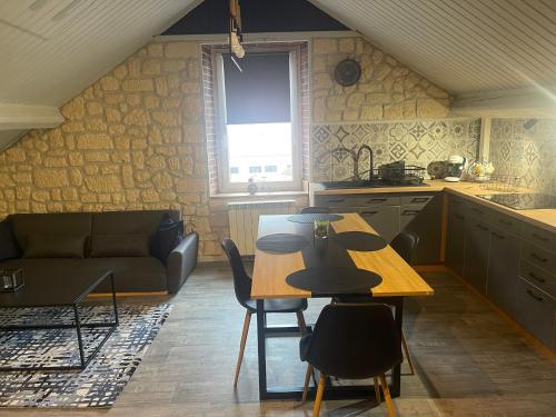 une cuisine avec une table, des chaises et un canapé dans l'établissement L appartement chez J&C, à Mandeure