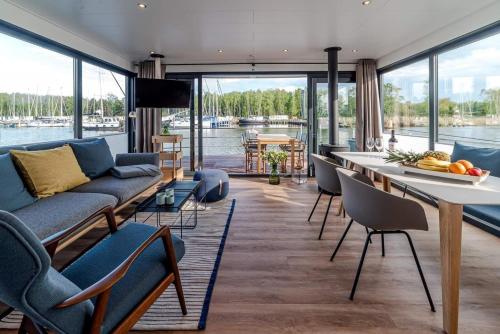 a living room with a couch and a table and chairs at Hausboot LP1 in Peenemünde