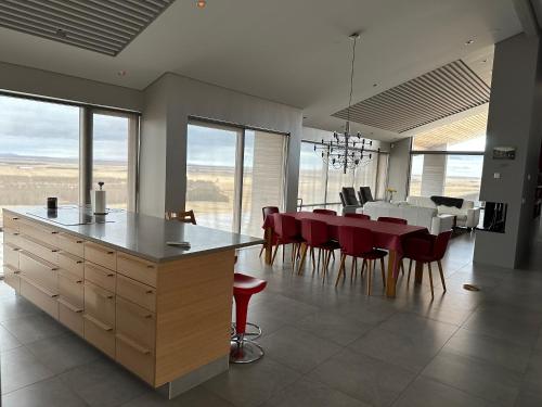 a kitchen and dining room with a table and red chairs at Hekla Adventures in Hvolsvöllur