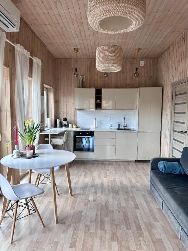 a living room with a table and a kitchen at Silazari Klapkalnciems in Klapkalnciems