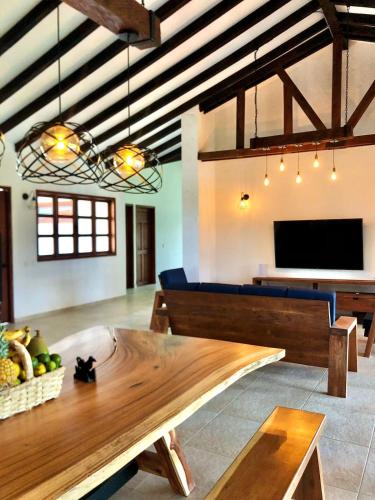 a living room with a wooden table and a tv at Finca Mutatá in Montenegro