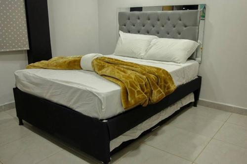 uma cama com um cobertor dourado em cima em Finca-Hotel en Guatape em El Peñol