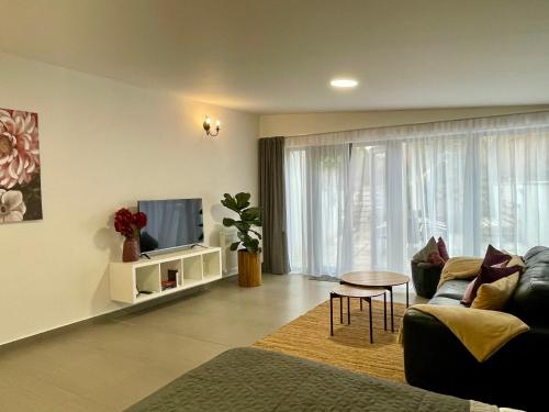 a living room with a couch and a tv at Pension Phoenix in Znojmo