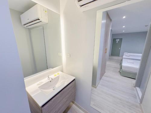 La salle de bains est pourvue d'un lavabo et d'un miroir. dans l'établissement GH Sander Hotel, à Guayaquil