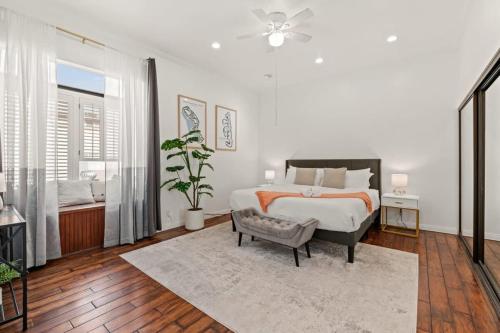 a white bedroom with a bed and a chair at Grand Desire - Vibrant - Luxury - Beachside treat in San Diego