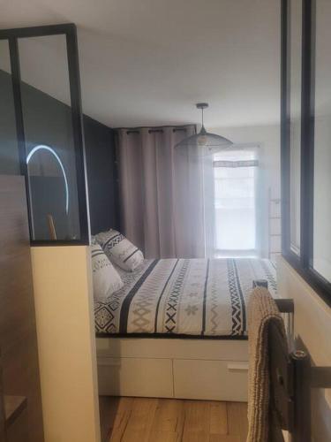 une chambre avec un lit et une fenêtre dans l'établissement Magnifique T2 meublé au pied du port, à Capbreton