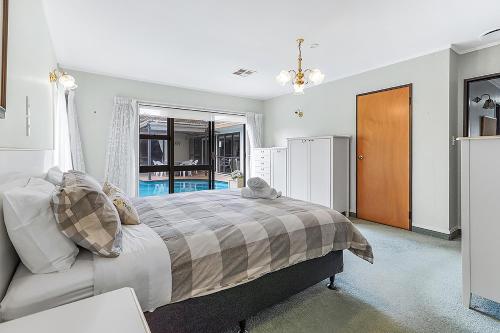a bedroom with a large bed and a window at Wow, spacious home with a pool in Hamilton