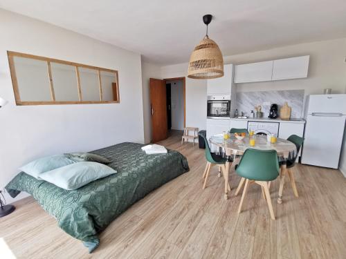une chambre avec un lit et une table et une cuisine dans l'établissement Appart'Cosy - clim - terrasse - ascenseur, à Cavaillon