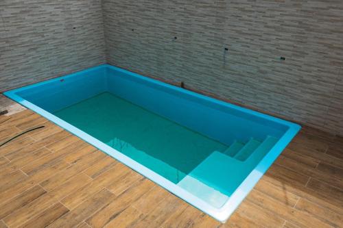 a large blue pool on the floor of a room at Pousada Caraguatatuba Praia Indaia Quarto 04 in Caraguatatuba