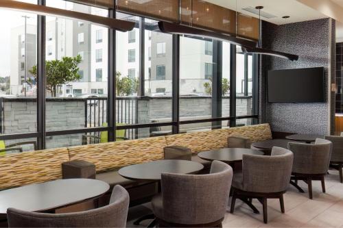 a restaurant with tables and chairs and a large window at SpringHill Suites by Marriott Pleasanton in Pleasanton