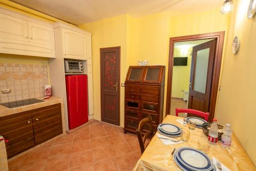 a kitchen with a table and a red refrigerator at Il Nido sul Lago in Capodimonte