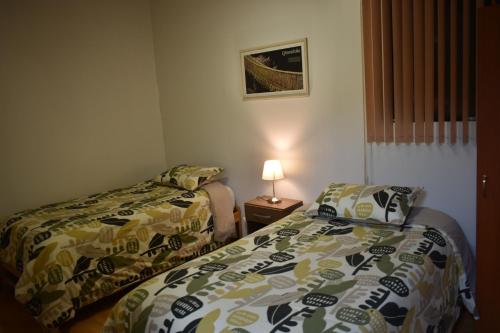 a small room with two beds and a lamp at saga andina in Cusco